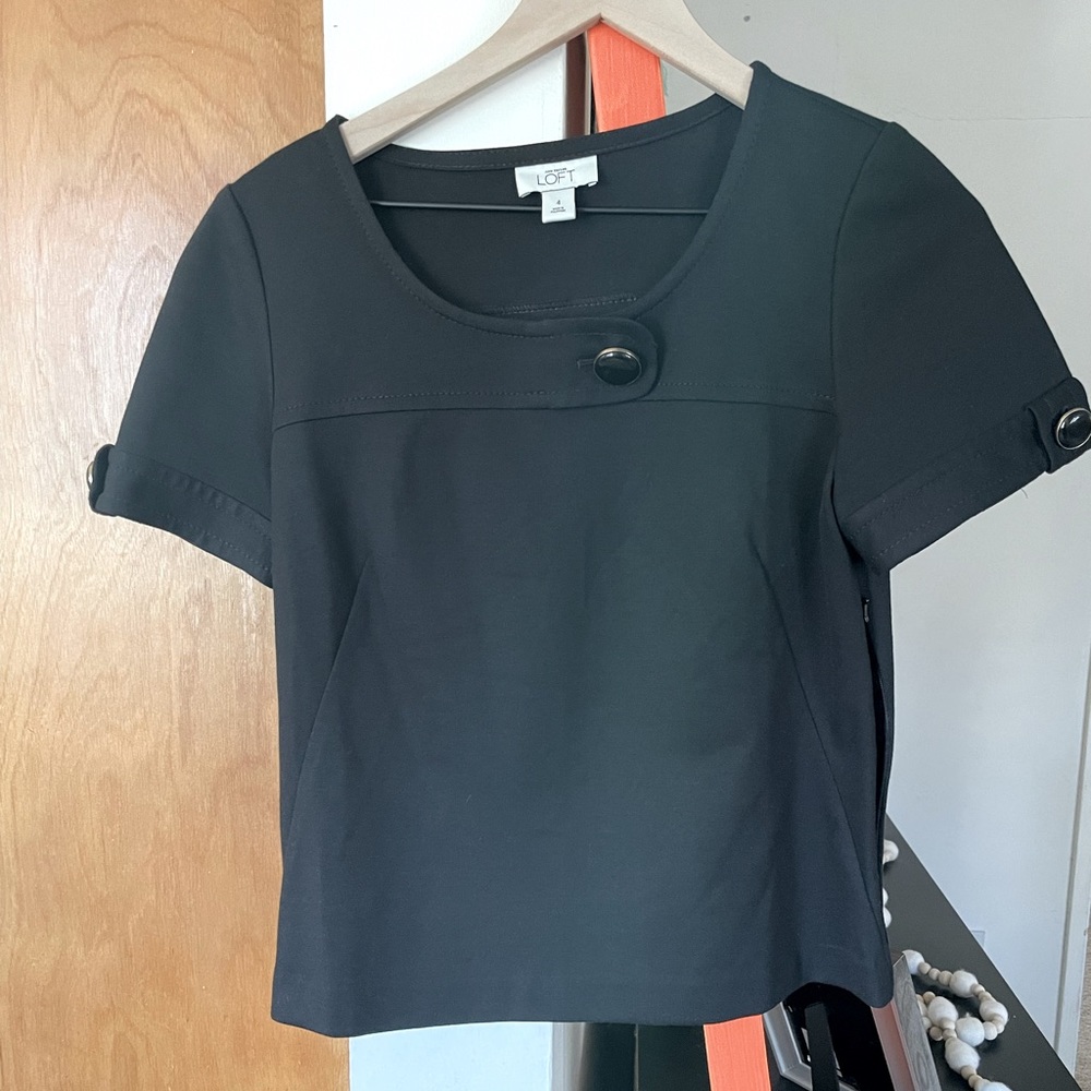 Black top with large round button with gold trim
